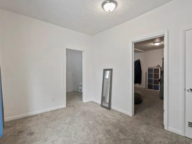 Unfurnished bedroom featuring light colored carpet and a textured ceiling