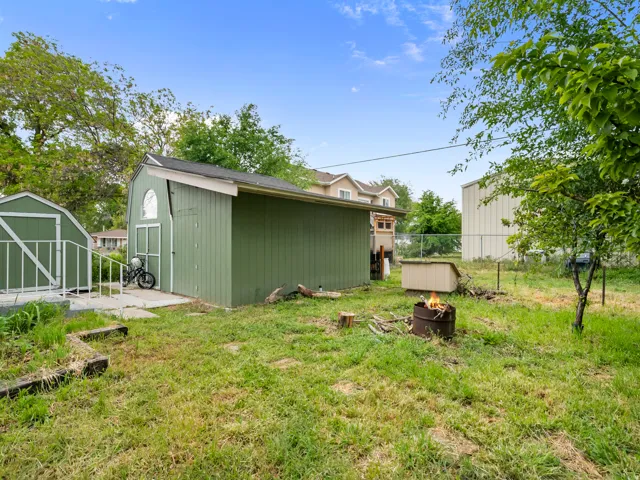 View of yard with a shed and an outdoor fire pit