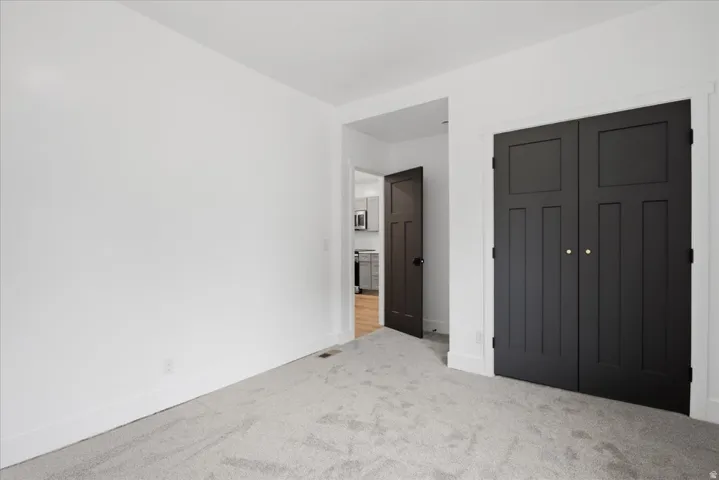 Unfurnished bedroom with a closet and light colored carpet