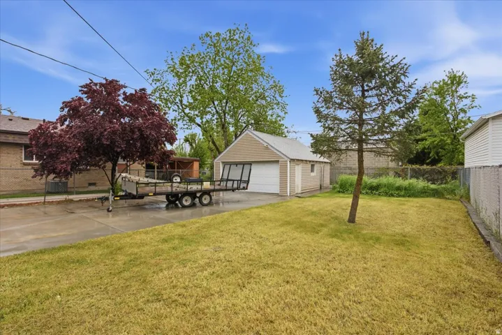 View of yard featuring a detached garage and an outbuilding