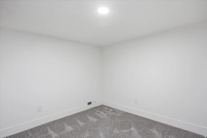 Carpeted spare room featuring baseboards