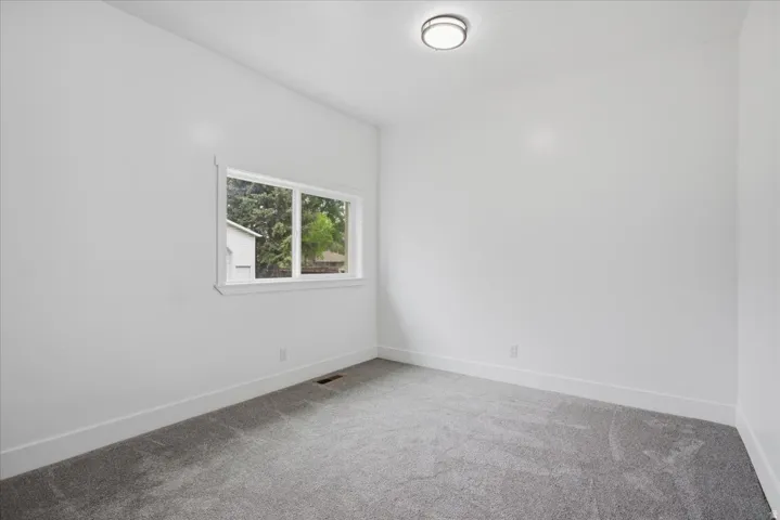 Empty room featuring carpet floors and baseboards