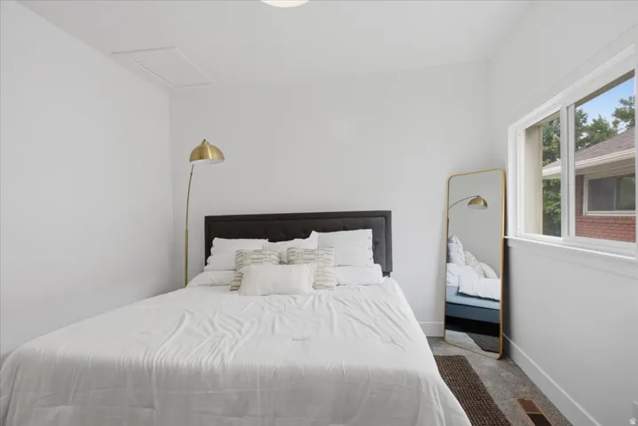 Carpeted bedroom featuring baseboards and attic access