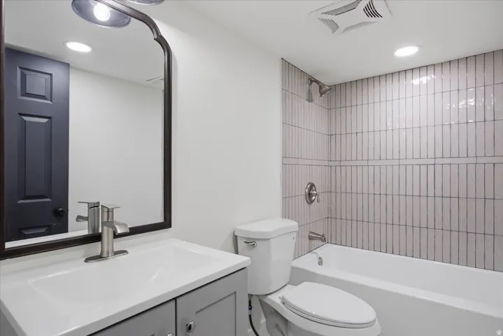 Full bath with vanity, shower / washtub combination, and recessed lighting