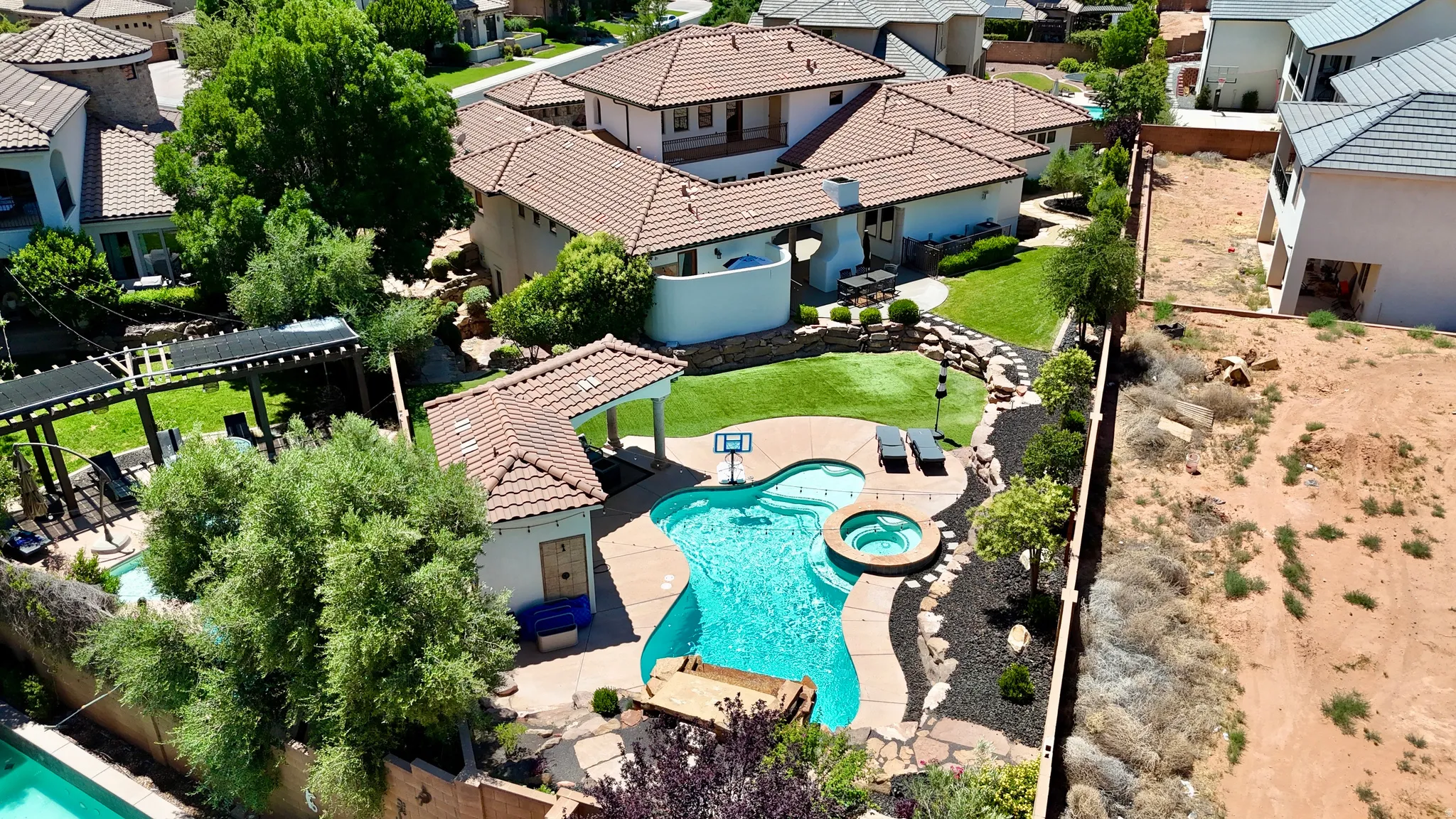 Resort-style backyard featuring a freeform swimming pool with integrated spa and rock accents