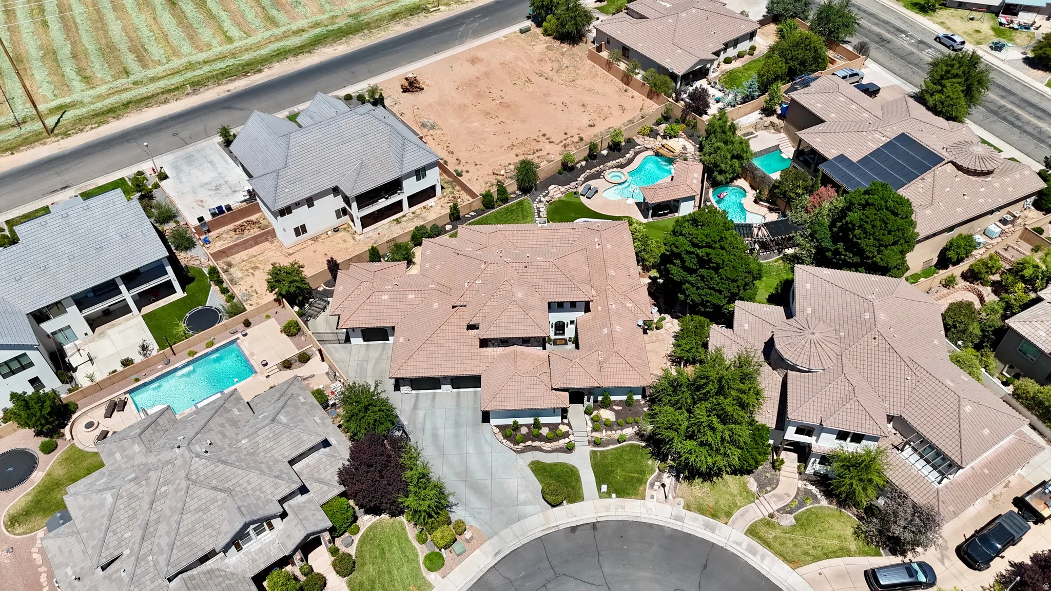 Aerial perspective showcasing a cul-de-sac property with mature landscaping and a long, curving driveway