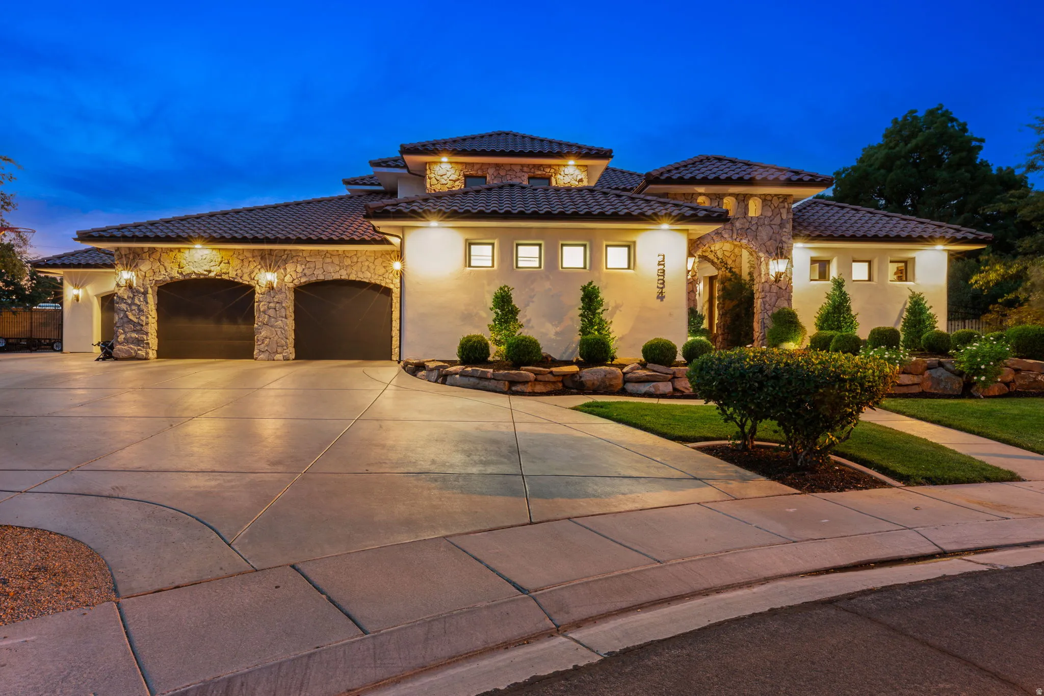 Stucco exterior with stone accents and a terracotta tile roof