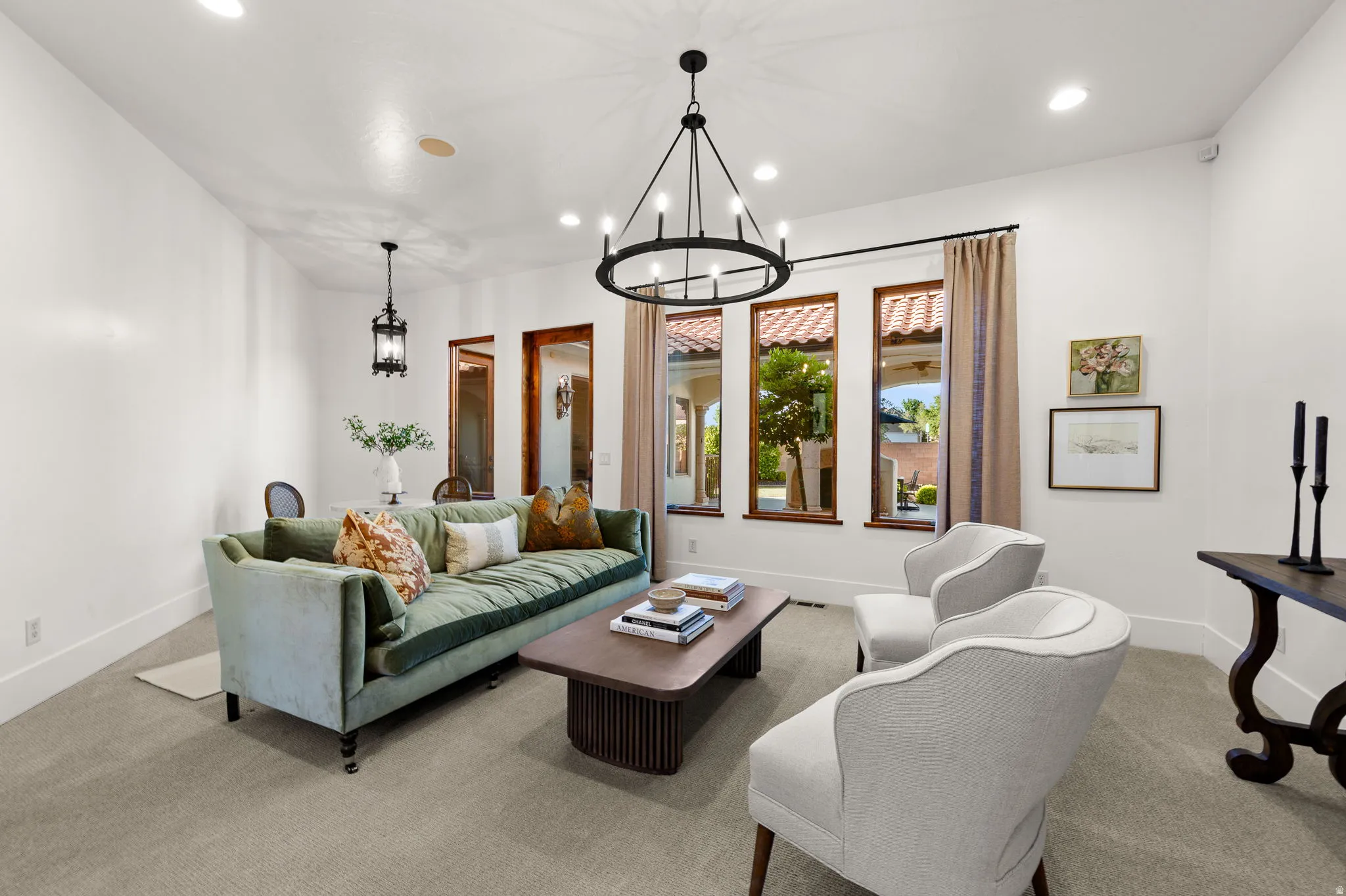 Living area with suspended lighting and carpet floors