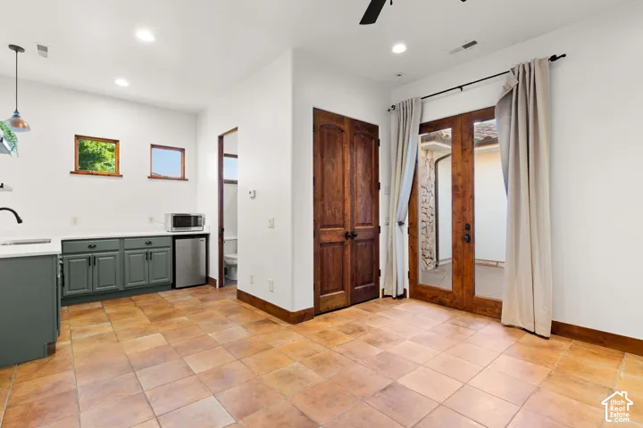Kitchen featuring stainless steel fridge, french doors, ceiling fan, hanging light fixtures, and light tile patterned flooring