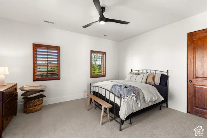 Bedroom with light carpet and a ceiling fan