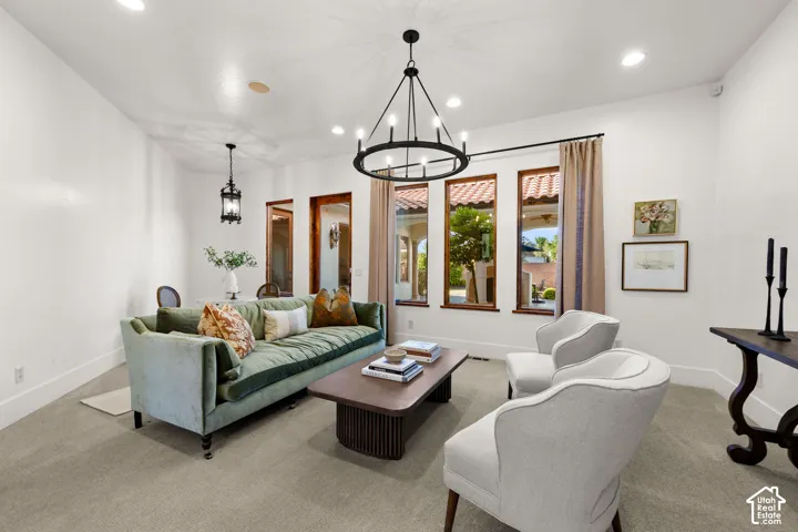 Living area with suspended lighting and carpet floors
