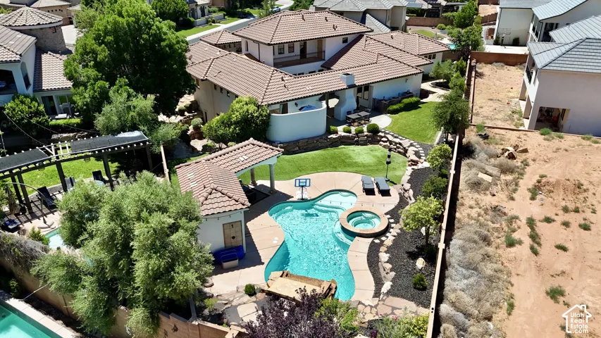 Resort-style backyard featuring a freeform swimming pool with integrated spa and rock accents