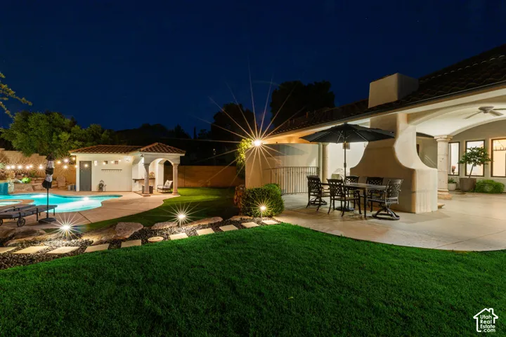 Expansive backyard featuring a freeform swimming pool, integrated spa, and a dedicated pool house with a covered patio