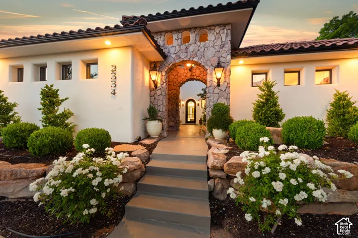 View of exterior entry with stone siding and stucco siding