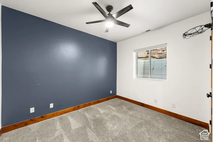 Unfurnished room featuring carpet flooring and a ceiling fan