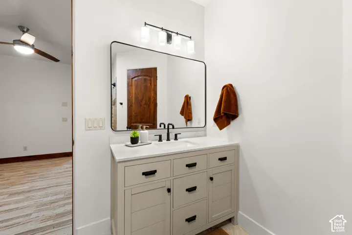 Bathroom featuring vanity, ceiling fan, and light wood-style flooring