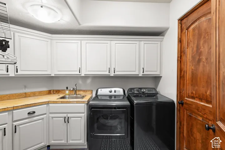Laundry area featuring separate washer and dryer and cabinet space