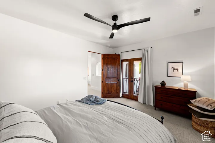 Carpeted bedroom featuring a ceiling fan