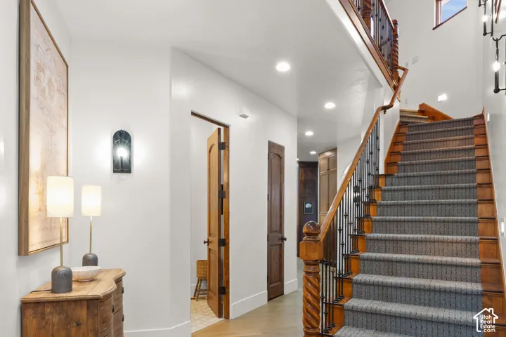 Stairway with wood finished floors and recessed lighting