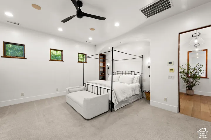 Bedroom with light colored carpet, ceiling fan, and recessed lighting