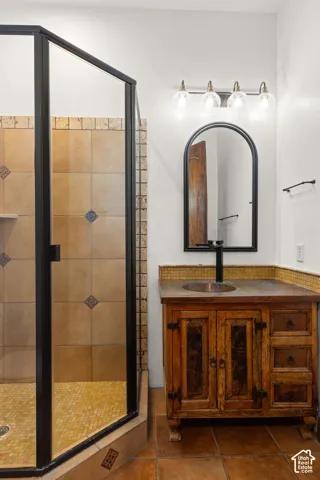 Full bathroom featuring vanity, a stall shower, and tile patterned floors