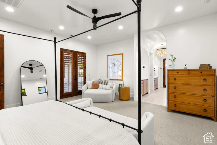 Bedroom featuring recessed lighting, light carpet, a ceiling fan, arched walkways, and access to outside