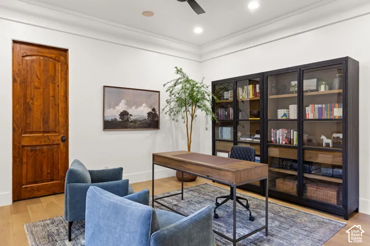 Home office featuring light wood-style flooring and a ceiling fan
