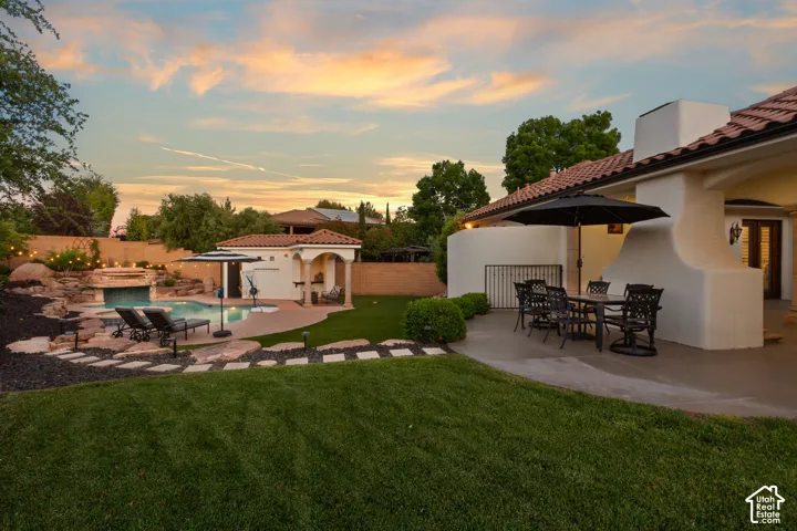 Fenced backyard with a patio, outdoor dining area, and an outbuilding