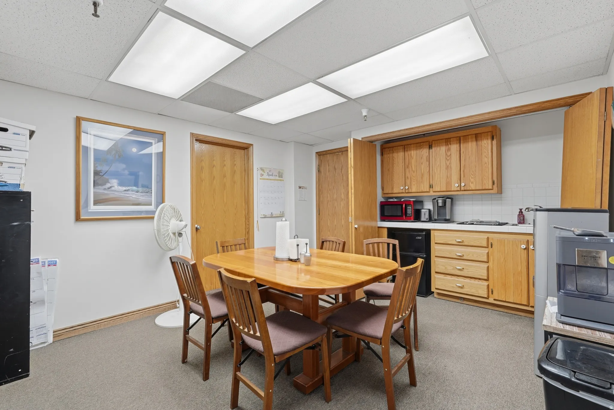 Dining space featuring a paneled ceiling and light colored carpet