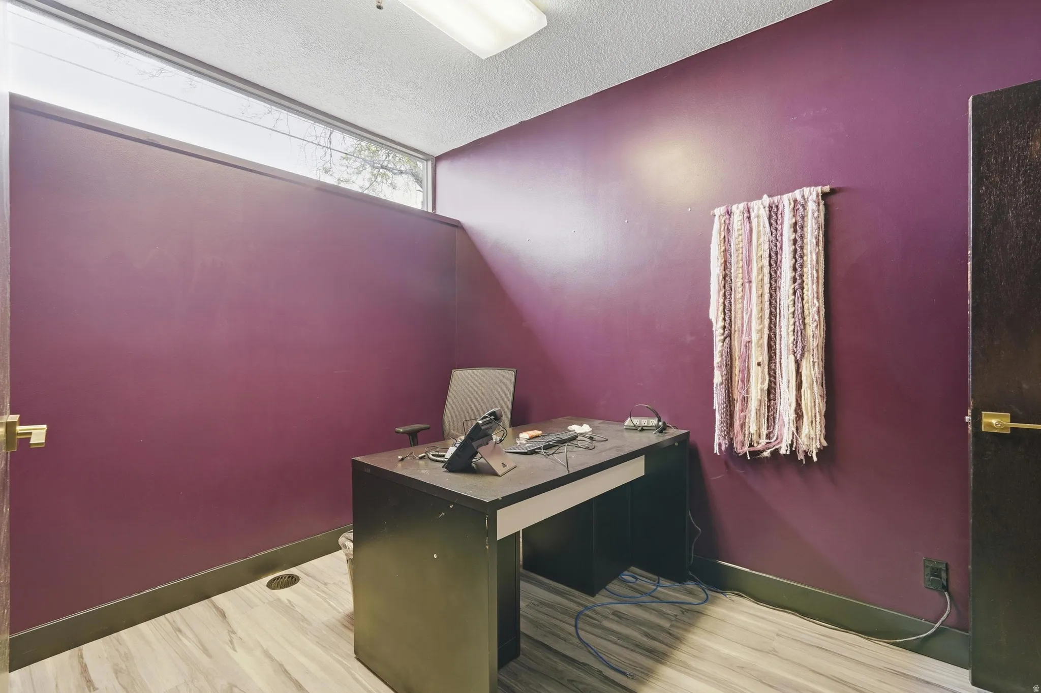 Office featuring light wood-style floors and a textured ceiling