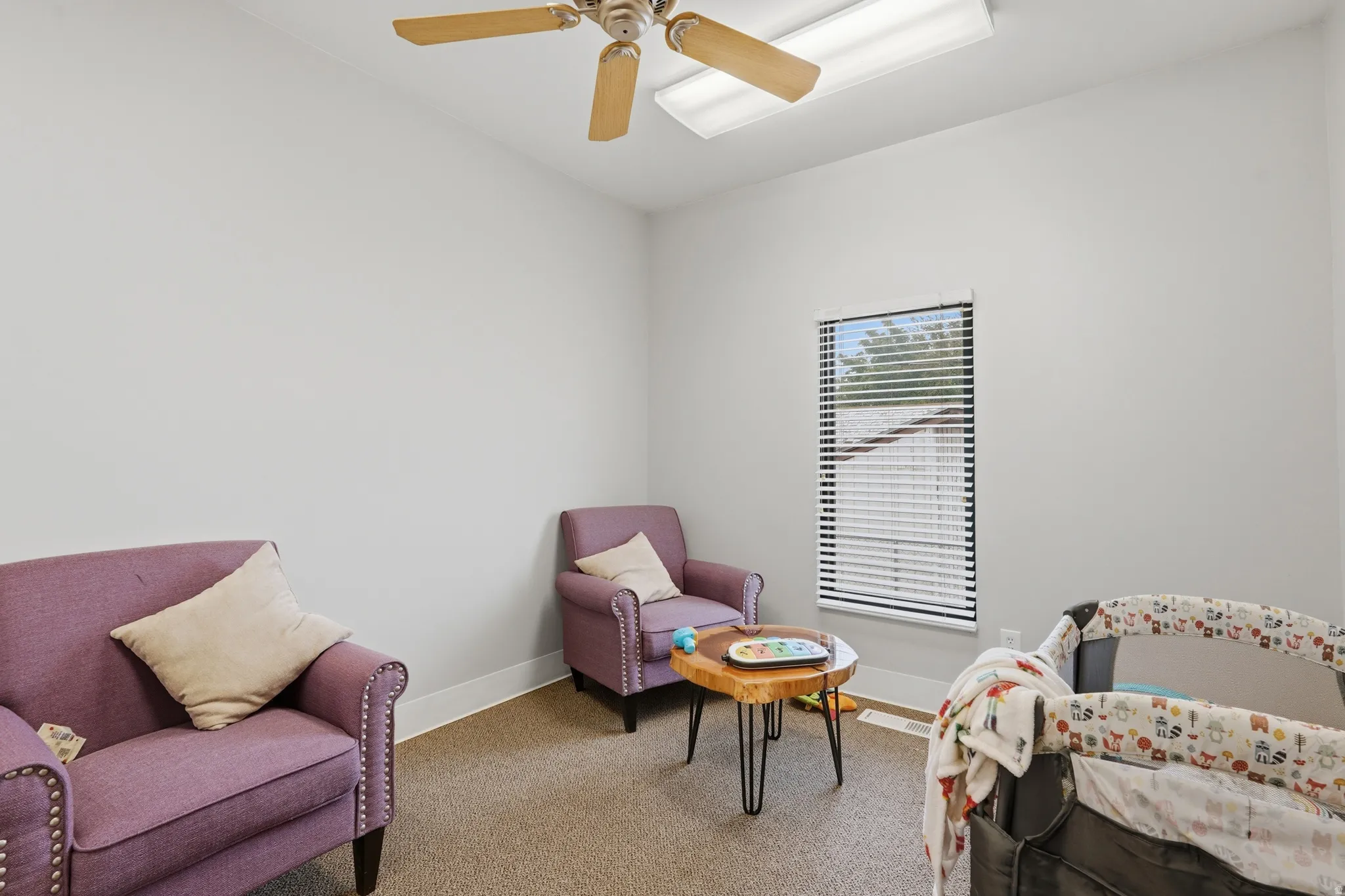 Living area with ceiling fan and light carpet