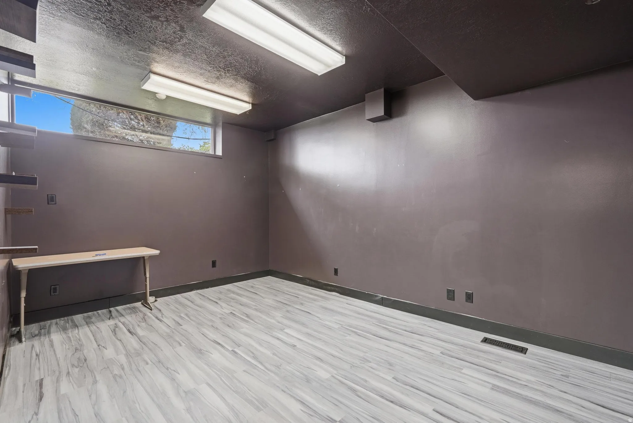 Spare room with a textured ceiling and light wood-style flooring