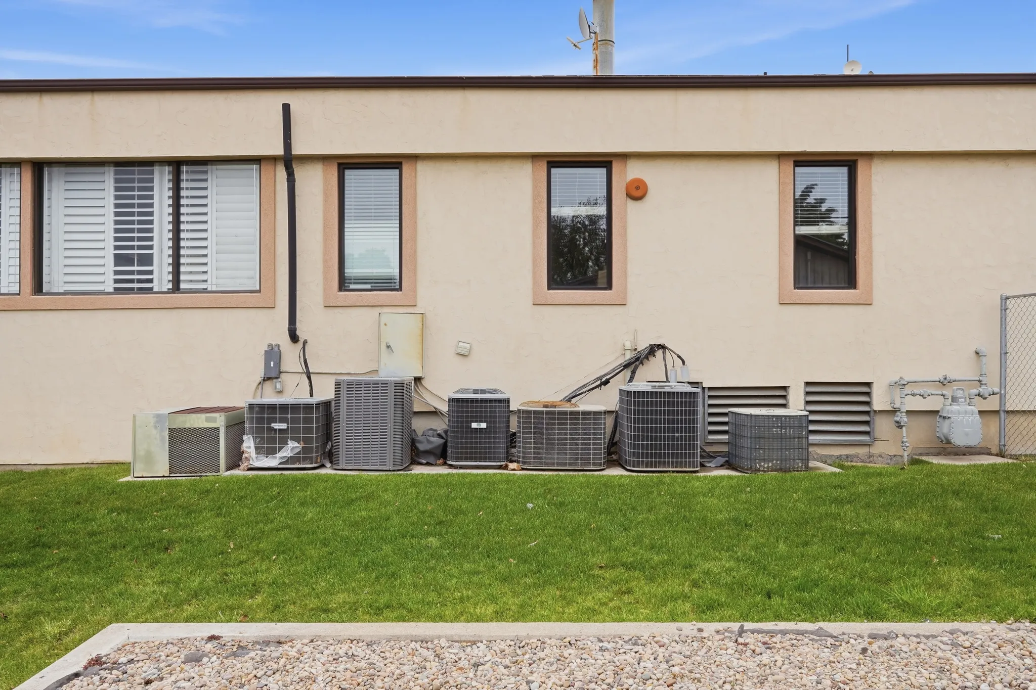Back of house featuring a lawn and stucco siding