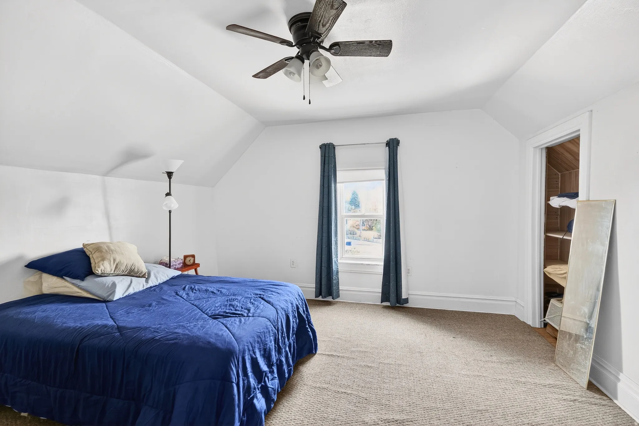 Bedroom with light colored carpet and a ceiling fan