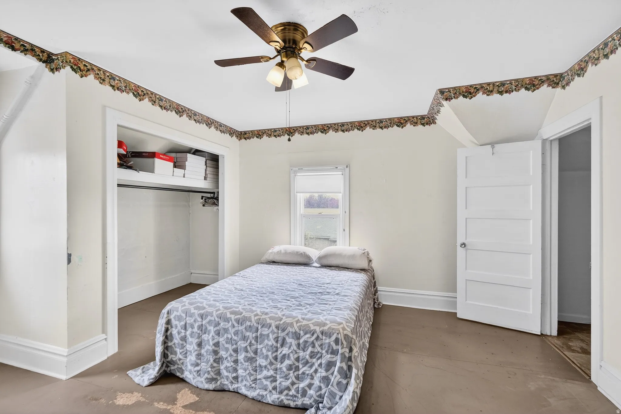 Bedroom featuring a closet, a ceiling fan, and concrete floors