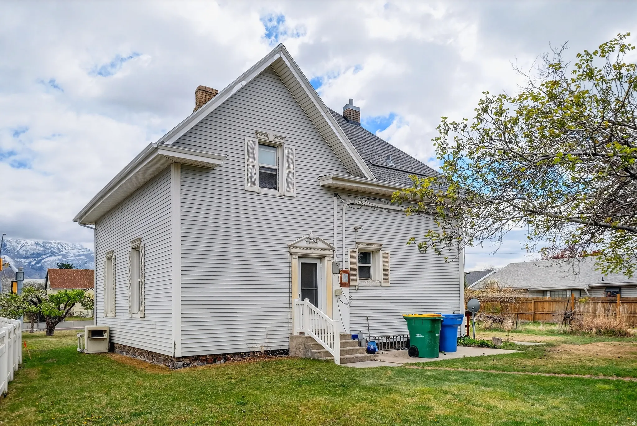 Rear view of property featuring a chimney and entry steps