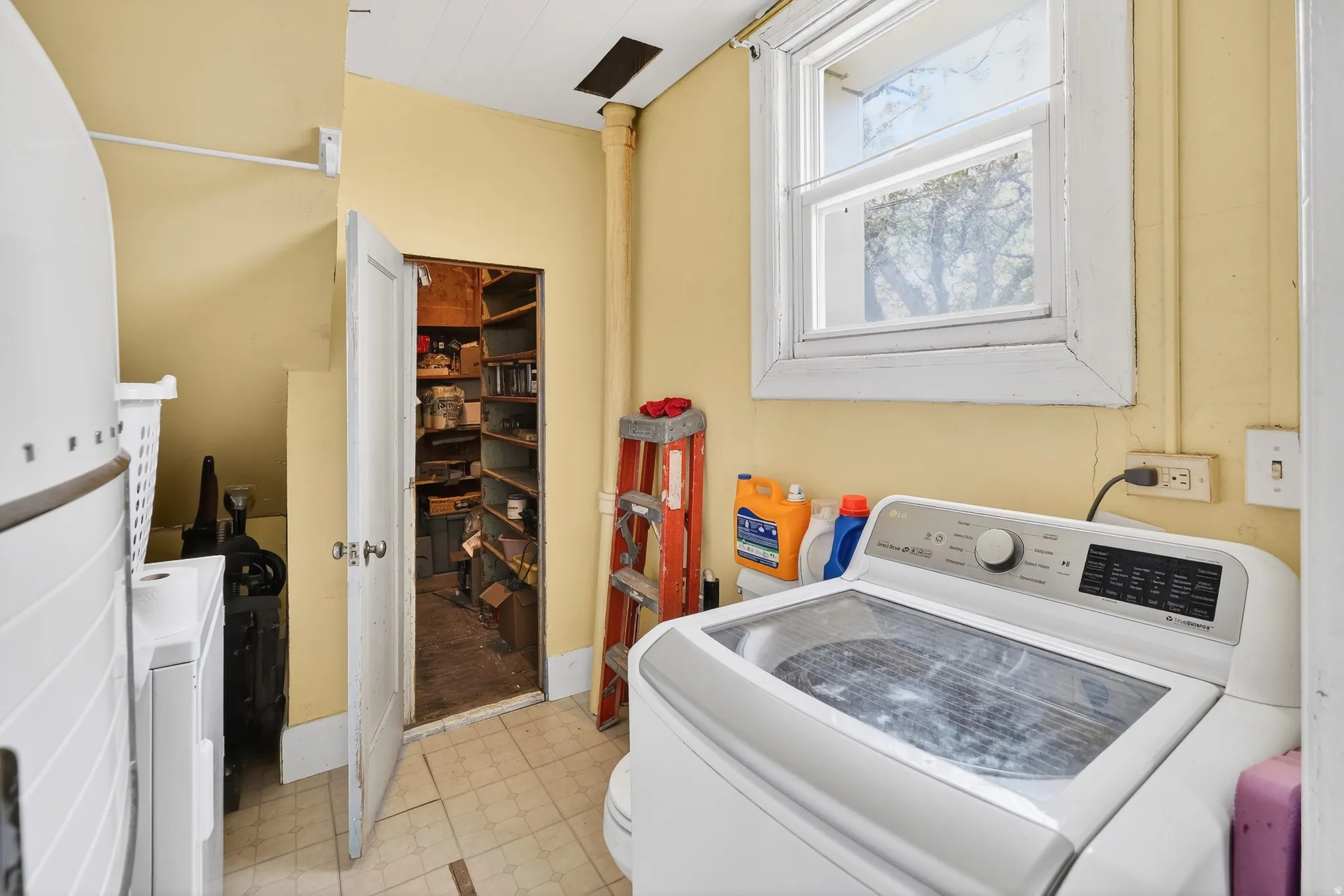 Laundry area with washer / dryer and light floors