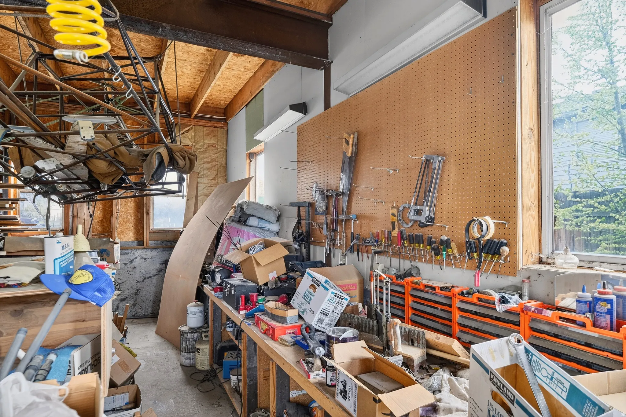 Miscellaneous room with a workshop area and unfinished concrete flooring