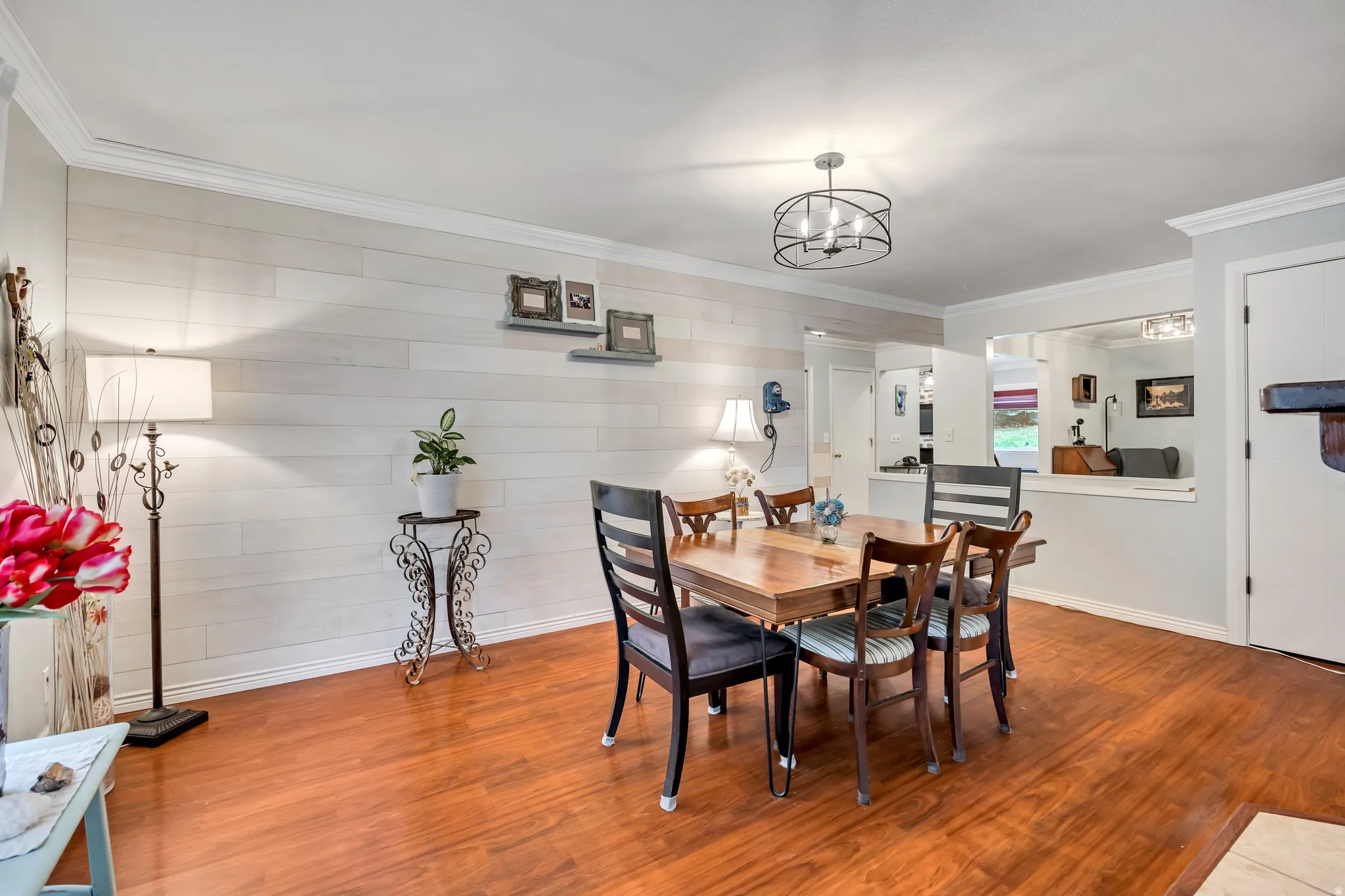 Dining area featuring ornamental molding, wood finished floors, wooden walls, and a chandelier