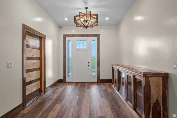 Entrance foyer featuring dark wood-style flooring and a chandelier