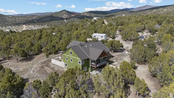 View of subject property featuring a mountain backdrop and a heavily wooded area
