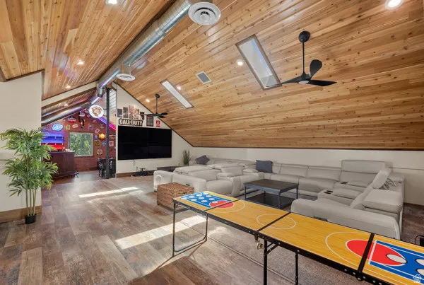 Living area with a ceiling fan, hardwood / wood-style floors, a skylight, and recessed lighting