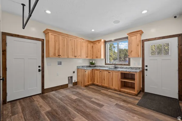 Laundry area with hookup for a washing machine, dark wood-style floors, hookup for an electric dryer, cabinet space, and recessed lighting