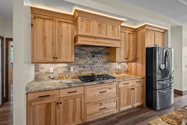 Kitchen with light stone counters, stainless steel appliances, and light wood finish cabinets