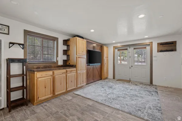 Kitchen with dark countertops, open shelves, wood tiled floors, recessed lighting, and light wood finish cabinets