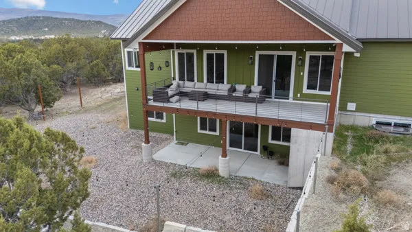 Rear view of house featuring a patio, board and batten siding, a mountain view, and a metal roof