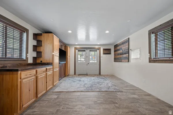 Kitchen with dark countertops, open shelves, wood tiled floors, and recessed lighting