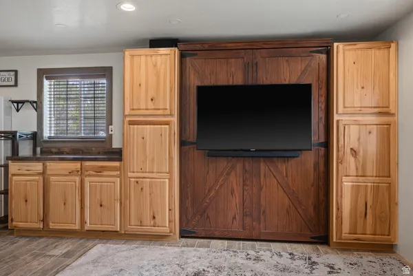 Kitchen featuring dark countertops, wood finish floors, light wood finish cabinets, and recessed lighting