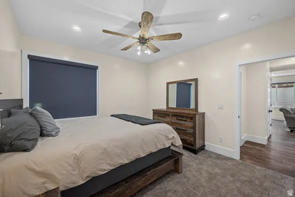 Bedroom featuring dark carpet, ceiling fan, and recessed lighting