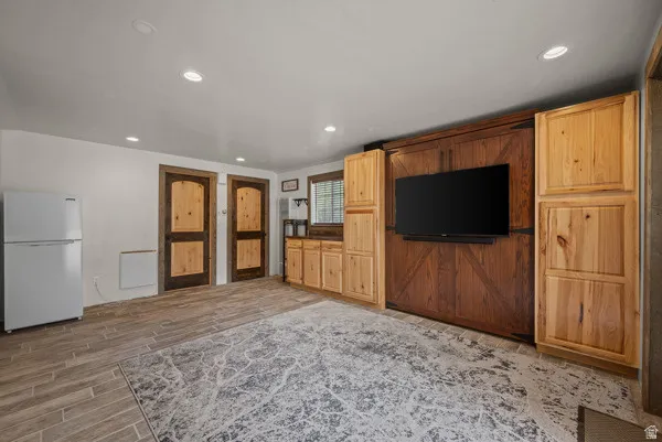 Unfurnished living room featuring wood tiled floors and recessed lighting